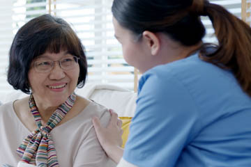 Elderly woman talking to caregiver