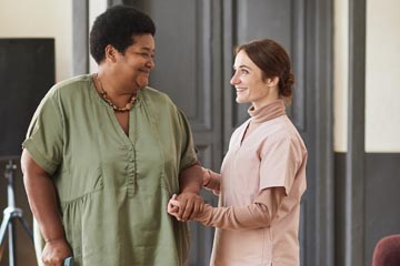 Elderly woman talking to caregiver