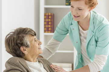 Elderly woman talking to caregiver